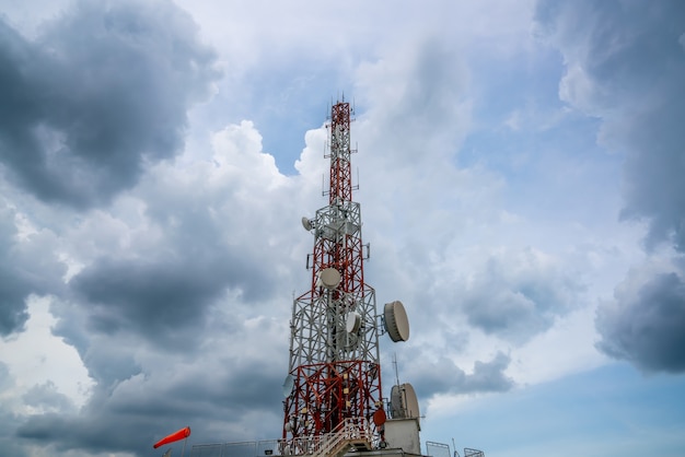 Large telecommunication tower against sky and clouds in background