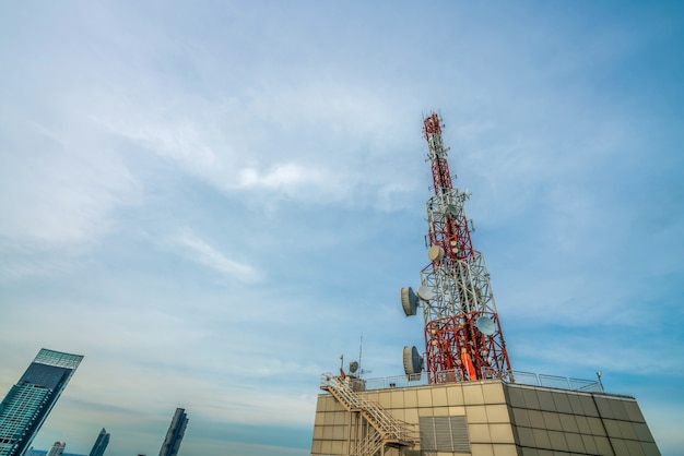 Large telecommunication tower against sky and clouds in background