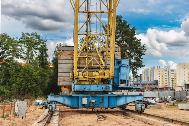 A large tower crane at a construction site against the backdrop of a modern monolithic house Modern housing construction industrial engineering Construction of mortgage housing