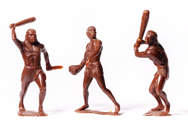 Large toy figures of primitive people on a white background.