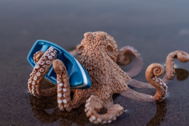 A large toy octopus sits in the water and holds a boat with tentacles