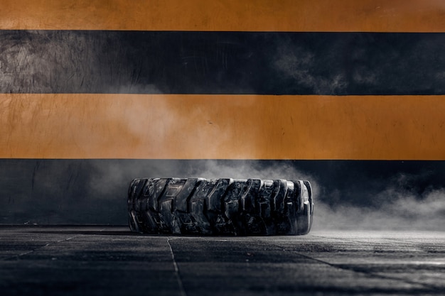 A large tractor wheel for crossfit lies on the floor in the gym. Sports equipment