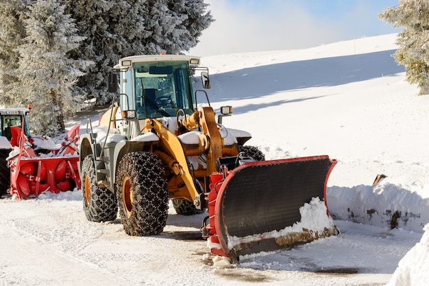 Large tractor with snow plow during a winter