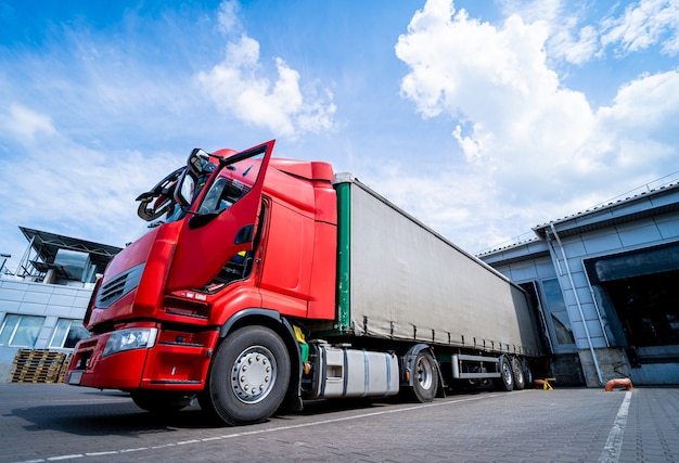 Large trucks near warehouse against blue sky background