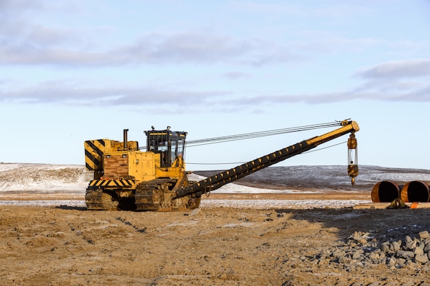 Large tube on loader. Tractor. Construction Marine offshore works.