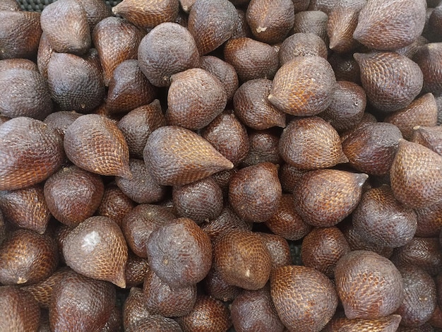 A large variety of snakefruit are displayed in a market