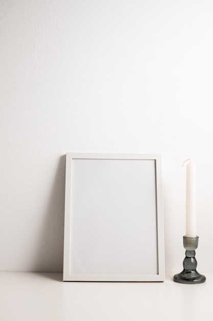 Photo large vertical white photo frame mockup with a candle