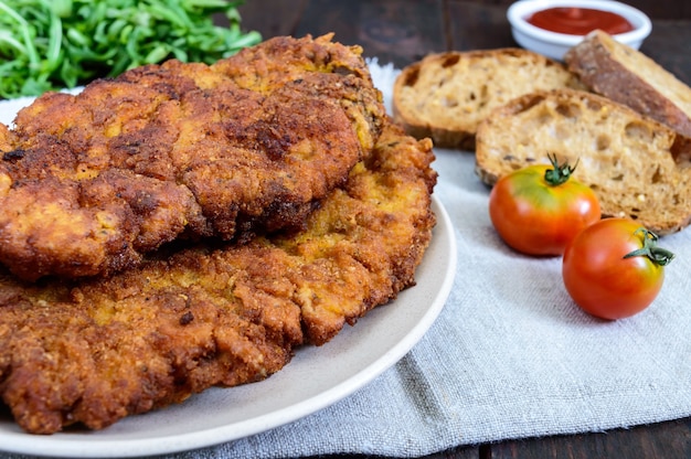 Una grande cotoletta viennese su un tavolo di legno scuro dark