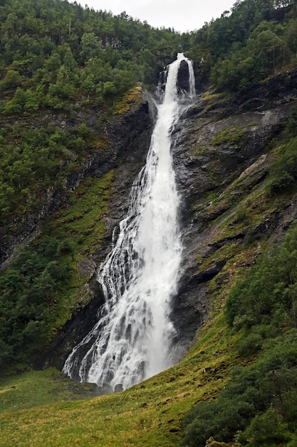 Large waterfall in mountainous and wooded areas