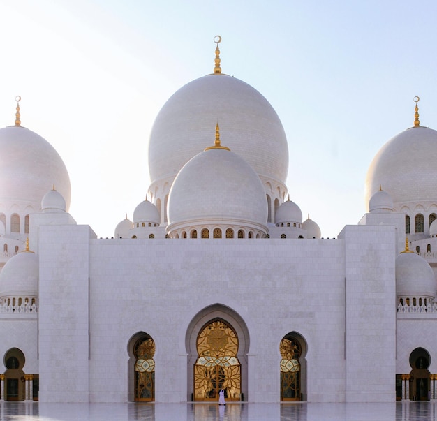 A large white building with a large dome and a gold sign that says sheikh zayed.