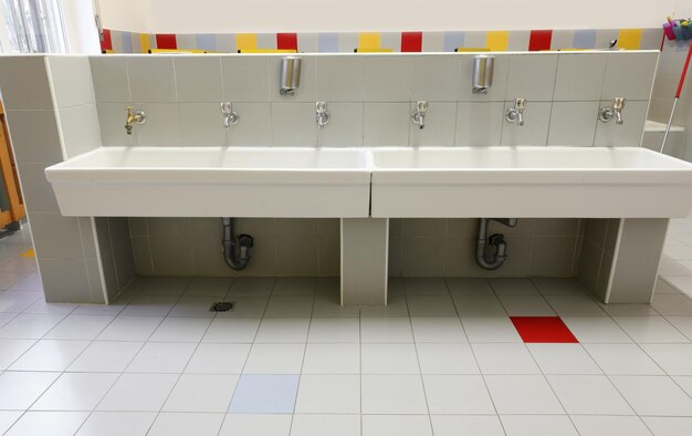 Photo large white ceramic sink in the school bathroom