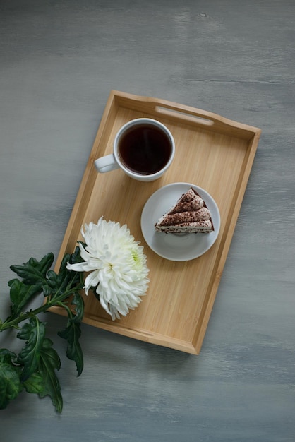 A large white flower on a wooden tray, top view