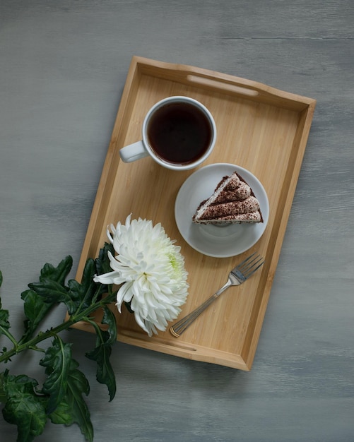 A large white flower on a wooden tray, top view