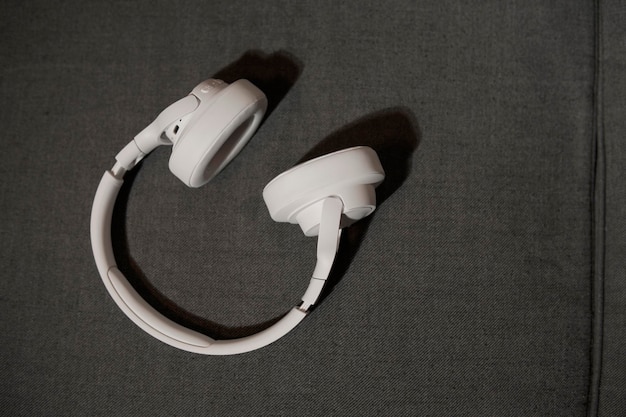 Large white headphones on gray sofa