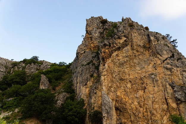 Large wild red limestone cliffs with sparse vegetation.