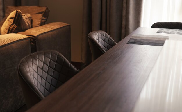 Large wooden dining table with soft chairs. Kitchen interior.