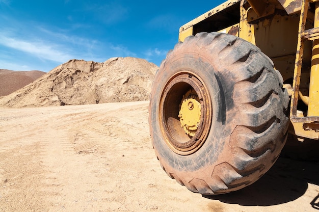 Photo a large yellow dump truck is parked in a dirt field