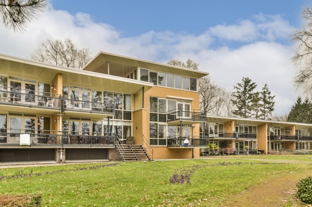 A large yellow house with glass windows on a hill