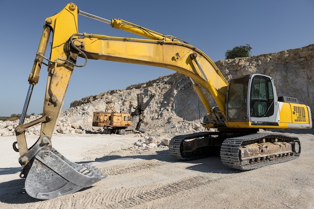 Photo a large yellow tracked excavator is mining rock in a quarry.