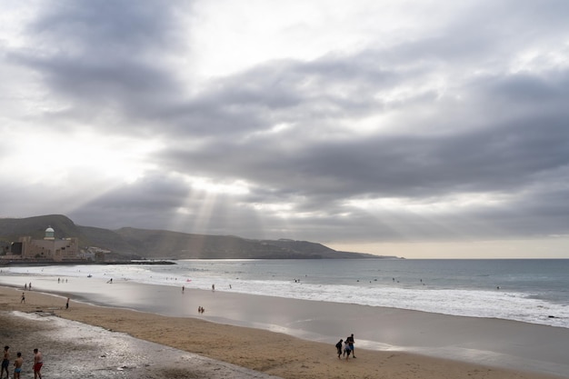 Las palmas spanje 30 maart 2021 zonnestralen doordringen de wolken boven het strand van las canteras op gran canaria