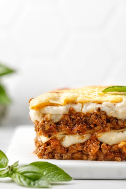 Lasagna Homemade Italian Lasagne with bolognese meat sauce bechamel cheese and basil on white board