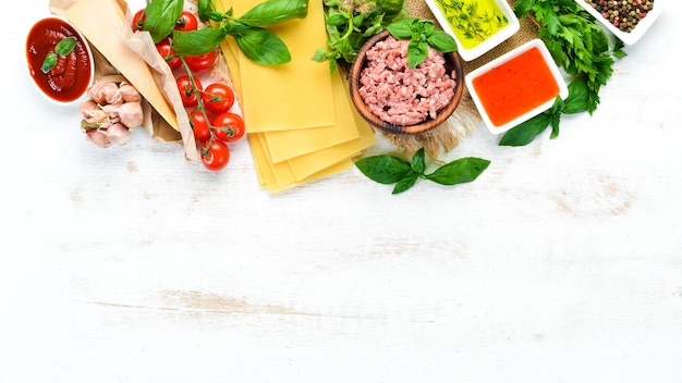 Lasagna and Ingredients On a white wooden background Top view Free space for your text