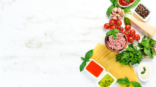 Lasagna and Ingredients On a white wooden background Top view Free space for your text