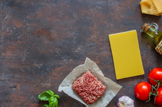 ラザニア、トマト、ひき肉、その他の食材。暗い背景イタリア料理。