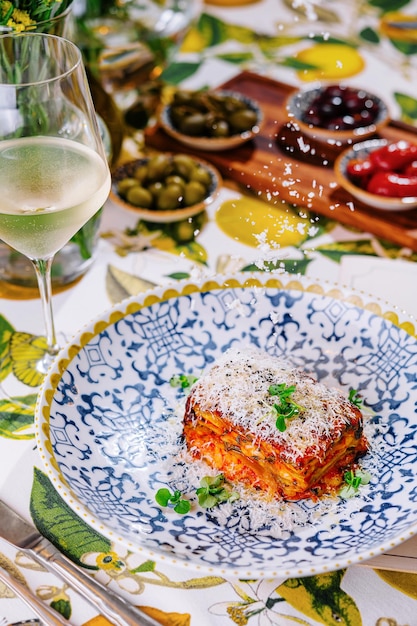 Foto lasagna con un bicchiere di vino bianco