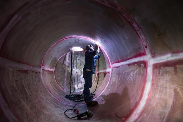 Foto lasboog argon werknemer mannelijk gerepareerd metaal is lasvonken industriële constructie tank roestvrij olie in besloten ruimtes.