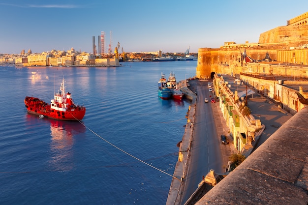 Photo lascaris battery, with the saluting battery and the upper barrakka gardens, senglea, church of our lady of liesse and quay of valletta at dawn