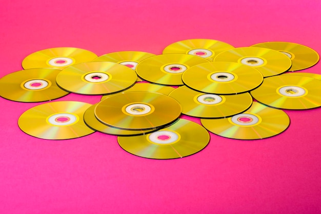 Laser Compact discs on a pink background with color reflection