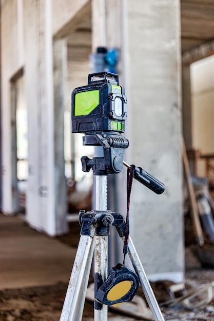 Laser level on a tripod at a construction site. Close-up. Taking measurements with a laser.