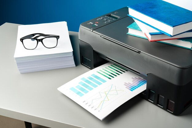 Laser printer on desk against blue background