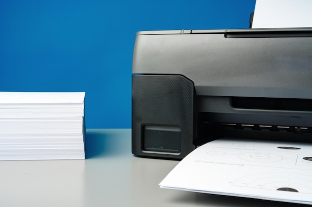 Foto laserprinter op het bureau tegen blauwe achtergrond