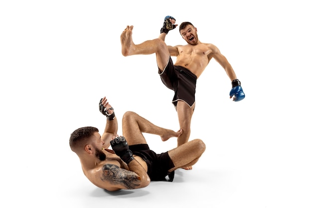 Last chance to win. Two professional fighters posing isolated on white studio background. Couple of fit muscular caucasian athletes or boxers fighting. Sport, competition and human emotions concept.