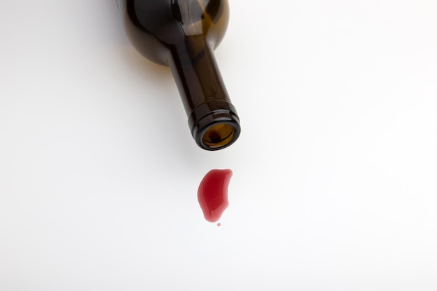 The last drop of red wine is dripping from the neck of the bottle