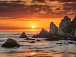 Photo last moments of the sun from the rocks of hendaye on an orange sunset france