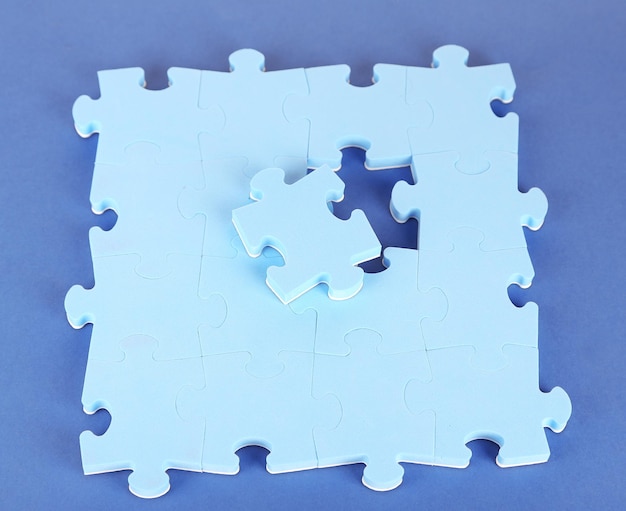 Foto ultimo pezzo di puzzle closeup su sfondo blu