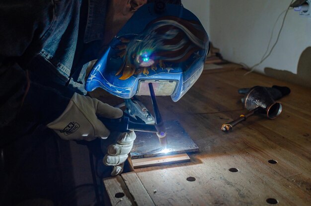 Laswerkzaamheden Een man met een beschermend masker Metaallassen Zware industrie Werk aan het lasapparaat