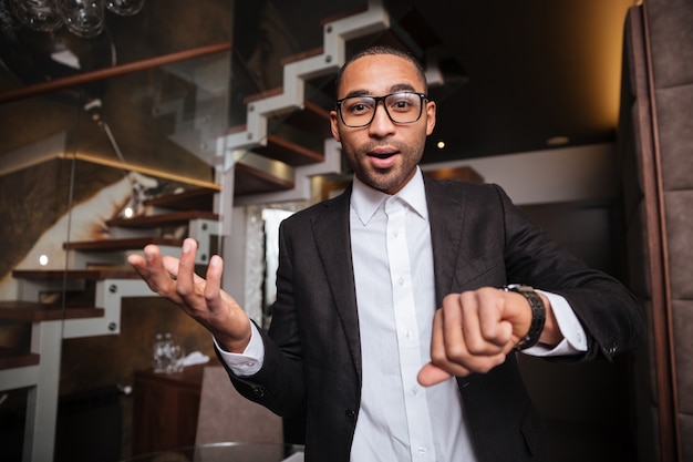 Late african man in suit  in hotel