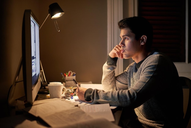 Late night study sessions Cropped shot of a young student studying late into the night