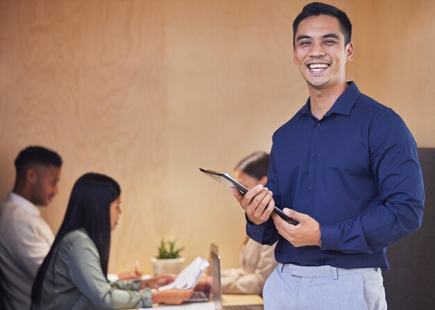 Laten we deze vergadering beginnen Bijgesneden portret van een knappe jonge zakenman die met een klembord in de bestuurskamer staat met haar collega's op de achtergrond