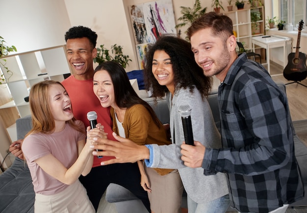 Laten we een karaokegroep van multiculturele vrienden doen die enthousiast zingen met microfoon terwijl