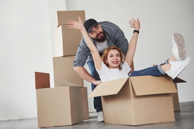 Laten we wat plezier maken. Gelukkig paar samen in hun nieuwe huis. Conceptie van verhuizen