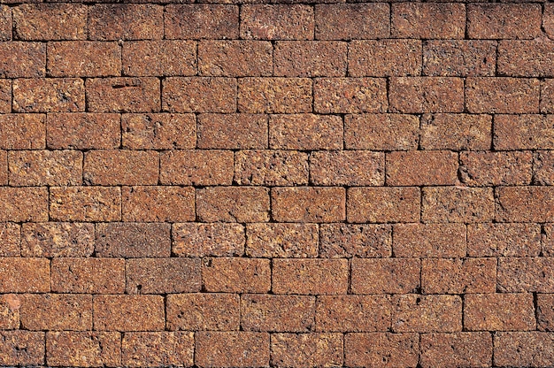 Lateriet stenen muur oppervlakte rode stenen bakstenen blokken close-up achtergrond.