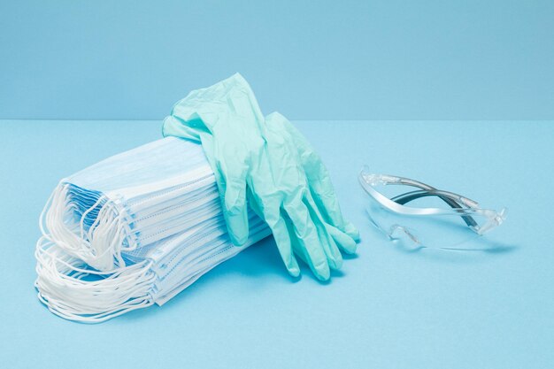 Latex gloves stacked medical masks and a safety glasses for personal protection Top view