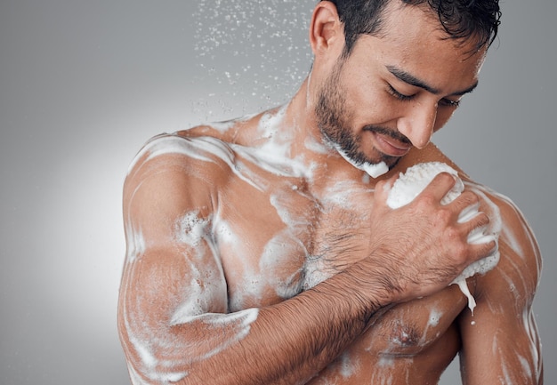 Lather it up Shot of a young man taking a shower against a grey background