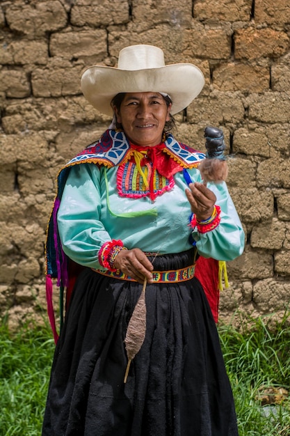 Latijns-Amerikaanse Andesvrouw die schapenwol verft met Peruaanse voorouderlijke natuurlijke producten