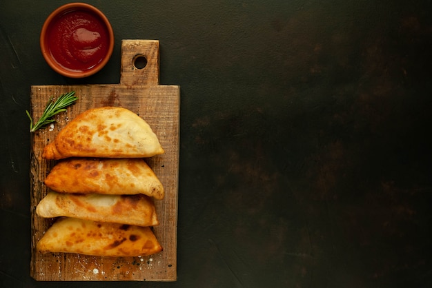 Latijns-Amerikaanse gebakken empanadas met tomatensaus met kopie ruimte voor uw tekst